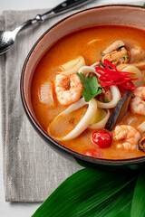 Spicy Asian tom yum soup with shrimp, squid, mussels and vegetables. Asian cuisine.