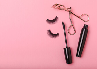 Composition with false eyelashes, mascara and eyelash brushes, eyelash curlers on a pink background. Makeup artist tools. Beauty concept. Makeup. Place for text. Place for copying. Flatley. MOCAP.