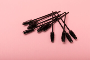 Eyelash extension brushes on a pink background. Brush for combing extended and false eyelashes....