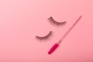 Eyelash extension brushes on a pink background. Brush for combing extended and false eyelashes. Brush for straightening eyelashes and eyebrows.