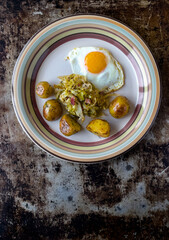 Pan fry egg with sweet white cabbage and baby potato in butter and dill, top view on the plate. Vertical