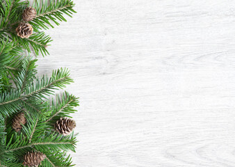 Background of Christmas tree branches. Christmas banner with twigs and cones on the side.