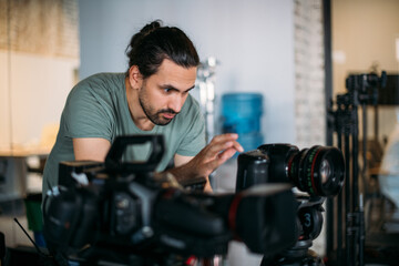 Fototapeta na wymiar Director of photography with a camera in his hands on the set. Filming process indoors, studio