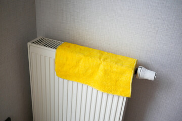  yellow color towel drying on heating radiator,