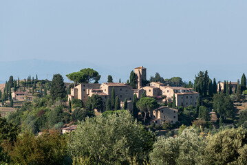 Weite Landschaften mit bepflanzten Alleen und typischer Bauweise in der Toscana Italien