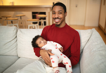 Happy african american father with infant baby in arms