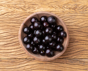 Jabuticabas on a bowl over wooden table