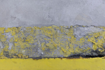 cement floor with a rusty edge and yellow markings