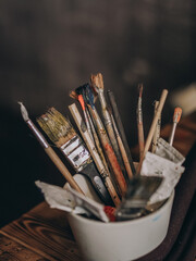 many artist brushes and tubes of paint