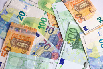 Pile of cash euro banknotes on the table in value of twenty euros, fifty euros, five euros, one hundred. Background with money.