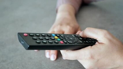 close up of women hand holding tv remote.