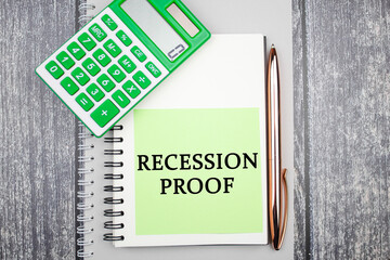 RECESSION PROOF text concept on a piece of paper next to a calculator. Financial business concept...