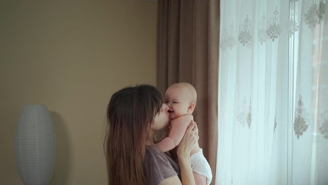 A young mother spends time with her cute daughter, the mother plays and throws the child up, the child laughs. Mother's Day.