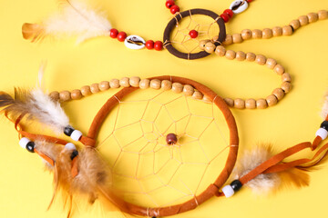 Beautiful dreamcatchers on yellow background, closeup