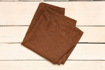 Clean folded napkin on light wooden background