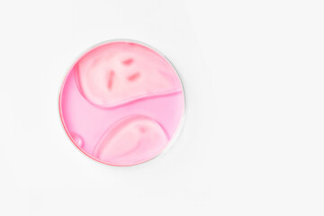 Petri dish on a light background. With pink liquid. Water stains, oil drops. Glassware. study. Chemical elements.
