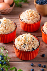 Blueberry muffins with powdered sugar and fresh berries on the table. Baked goods concept.