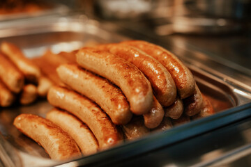 Hot grilled sausages with chilli on a grill in a fast food restaurant