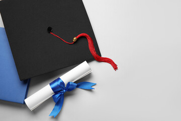 Diploma with blue ribbon, graduation hat and book on white background - Powered by Adobe