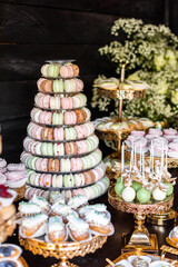 Delicious wedding reception candy bar Dessert table for a wedding outdoor party. Ombre cake, cupcakes, sweetness, macaroons and flowers gypsophila