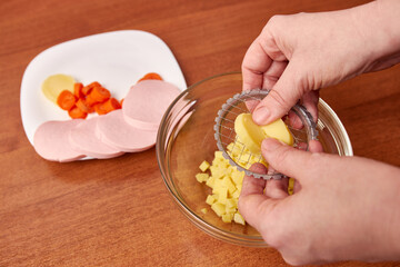 With the help of manual slicing, potatoes are chopped for salad preparation.