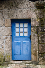 A bright blue door in a stone wall.