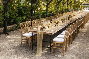 Wedding decorations. Served wedding table with golden plates, golden chairs, napkins, decorative...
