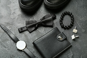 Set of stylish male accessories with bow tie on dark background