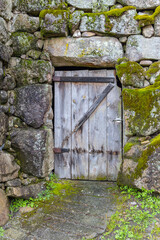 A wooden door in an old stone wall.