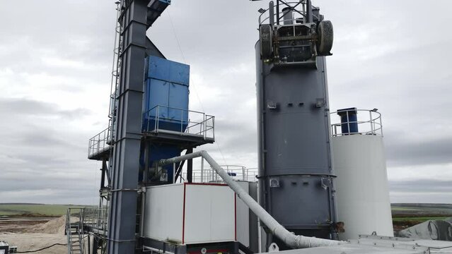 Gravel processing tower with mobile elements at mining quarry under cloudy sky aerial view. Extracted rocks processing technology