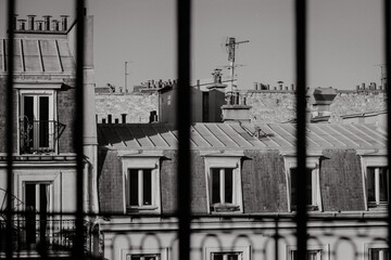 Vue des toits de Paris à travers la fenêtre en noir et blanc