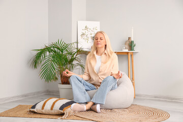 Mature woman meditating at home