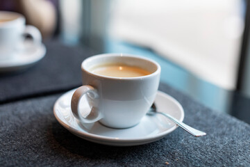Taking a coffee break in a restaurant - white porcelain cups of coffee on a cafe table 