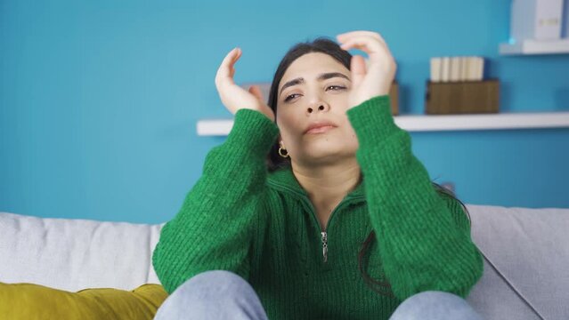 Young woman depressed and stressed at home.
Sad and afflicted young woman at home feeling depressed and troubled.
