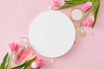 Top view photo of white circle perfume bottle makeup powder bijouterie earrings and tulips flowers on pastel pink background with blank space. Women's Day concept.