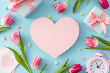 Top view photo of pink heart colorful tulips flowers gift boxes postcard alarm clock and hearts baubles on isolated pastel blue background with blank space. Mother's Day concept
