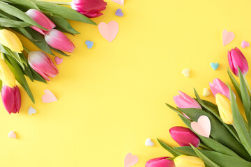Mother's Day celebration idea. Creative layout made of origami paper hearts bouquets of flowers colorful tulips and hearts baubles on isolated light yellow background. Flat lay with copyspace
