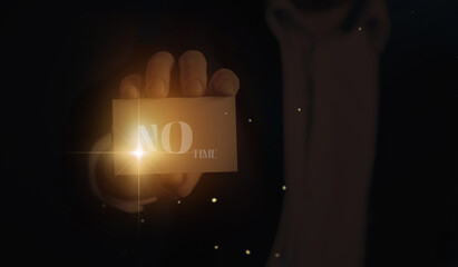 A man holds between his fingers a white sheet of paper bearing the words No Time