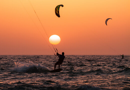 People ride a Kiteboarding during the sunset. Mediterranean sea, Israel