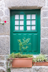 A green painted door in a stone building.