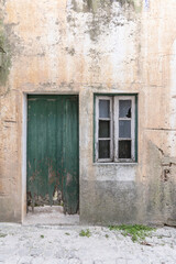Fototapeta na wymiar An old green wooden door in a stucco house.