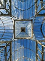 Foto op Plexiglas An interesting combination of glass and metal in Palacio de Cristal located in the de El Retiro park in Madrid on a sunny day, Madrid, Spain. © bARTkow