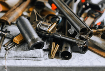 Retro firearms, rifle with ammunition, revolver with cartridges, parts and accessories close-up lie...