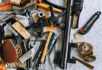 A bunch, a lot of tools scattered randomly on a table in a mechanic's workshop. Close-up photo,...
