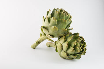 Obraz premium two green artichokes on a white background