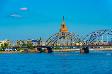 view of the zeppelin hangars and the academy of sciences building next to a steel railway bridge in the Latvian capital Riga. © dudlajzov