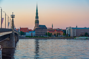 Sunset at the old town of riga including saint peters church viewed over daugava river, Latvia.