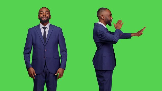 Modern employee sending air kisses in studio and doing romantic gesture, feeling optimistic and positive on camera. Young adult doing kissy face over green screen backdrop, showing approval.