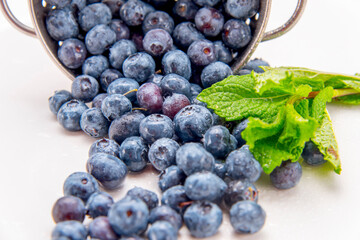 A colender of fresh blueberries and mint