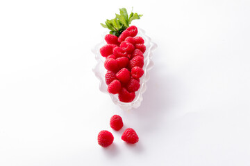 A glass boat of fresh whole raspberries